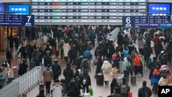 Para pemudik tiba di area keberangkatan untuk naik kereta di Stasiun Kereta Api Beijing Barat menjelang Tahun Baru Imlek, Jumat, 24 Januari 2025. (Foto: Aaron Favila/AP Photo)