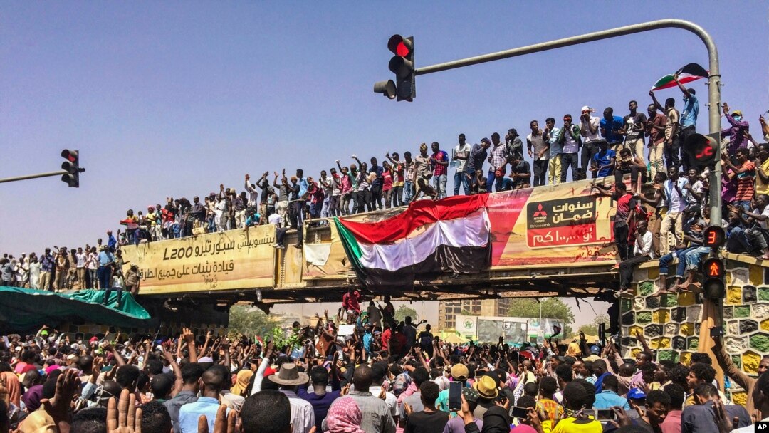  Abari mu myiyerekano basaba perezida Bashir Gutanga imihoho, hanze y'ibiro bikuru vya gisirikare i Khartoum, 09/04/2019.