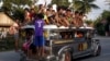 FILE - Residents ride on top of an overcrowded "jeepney", a locally manufactured public transport, along a highway in Mogpog town on Marinduque island in central Philippines, April 8, 2015. 