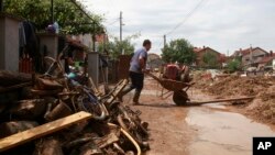 A man pushes a wheelbarrow with mud from his flooded house after a storm, in the village of Stajkovci, just east of Skopje, Macedonia, Aug. 8, 2016.