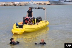 FILE - Emirati divers take part in an underwater search operation to recover rubble and bodies that were washed away into the sea during the September 10 flood, at the port of Libya's eastern city of Derna, on September 20, 2023.