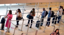 Travelers wait to clear the security checkpoint at Love Field airport, May 28, 2021, in Dallas.