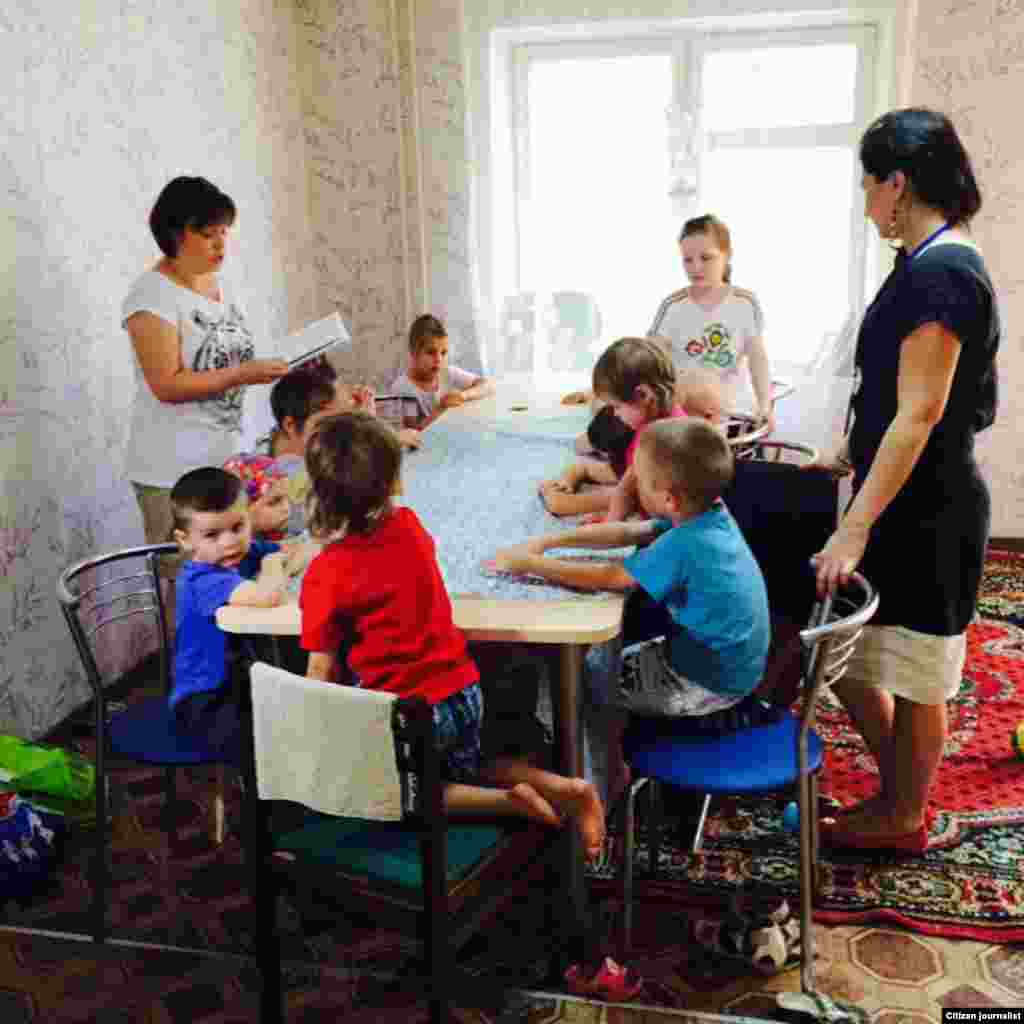Volunteer psychologists read to internally displaced children (referred to as IDP) at a resettlement house in Kyiv, June 3, 2015. (Daniel Schearf/VOA)