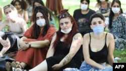 Women wearing protective masks look on during a protest organised by Ankara Women's Platform in Ankara, on July 26, 2020, in support of a landmark treaty on combating violence against women.