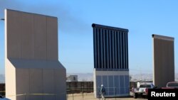 FILE - Three of U.S. President Donald Trump's eight border wall prototypes are shown near completion along U.S.- Mexico border in San Diego, California, Oct. 23, 2017. 