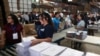 Trabajadores electorales organizan formularios de votación antes de las elecciones presidenciales en San Marcos, El Salvador, el 23 de enero de 2024.