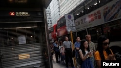 10月5日，人们在一关闭的香港地铁站外等公共汽车。（路透社）