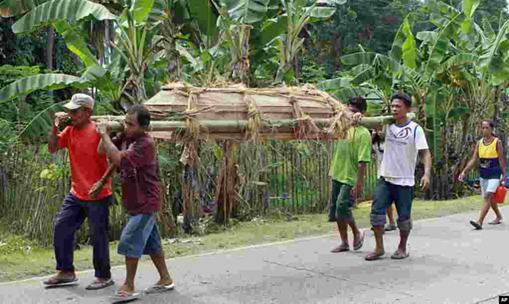 Villagers carry coffin of a relative who was killed by a huge boulder during an earthquake in La Libertad, Negros Oriental in central Philippines February 7, 2012. (Reuters)