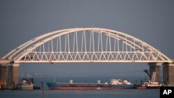 FILE - A Russian tanker under the Kerch bridge blocks the passage to the Kerch Strait near Kerch, Russia-annexed Crimea, Nov. 25, 2018.