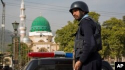 Seorang polisi Pakistan melakukan penjagaan di dekat makam seorang Imam Sufi di Sindh, Islamabad, Pakistan pasca serangan militan ISIS tahun lalu (foto: dok). 