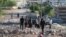 People gather amidst the rubble and damaged vehicles following reported air strikes by the Syrian regime ally Russia, in the town of Kafranbel in the rebel-held part of the Syrian Idlib province on May 20, 2019. 