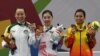 Qi Xinyi dari China (tengah), meraih medali emas wushu untuk nomor changquan putri, bersama peraih medali perak Li Yi (kiri) dari Macau dan peraih medali perunggu, Hoang Thi Phuong Giang dari Vietnam, 22 Agustus 2018.