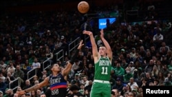 Payton Pritchard (11) des Boston Celtics tire face à Marcus Sasser (25) des Detroit Pistons, au TD Garden, USA, le 12 décembre 2024.