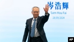 FILE - The sole candidate for the upcoming election for the Macao chief executive post, Sam Hou Fai, the city's former top judge, waves at a press conference in Macao, Sept. 28, 2024. 