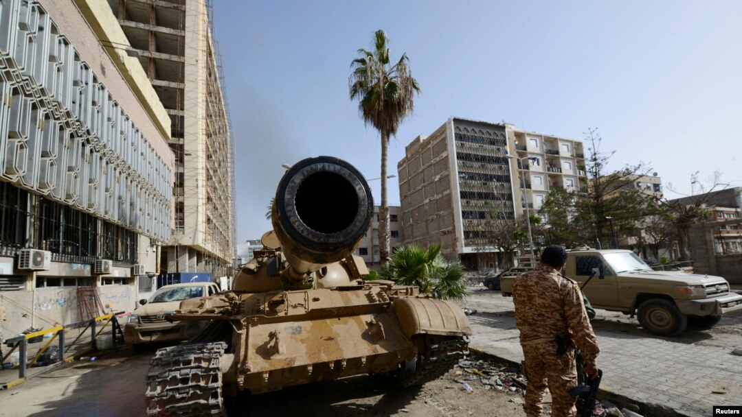 Anggota pasukan pro-pemerintah Libya berdiri dekat tank di Benghazi, Libya (21/1). (Reuters/Esam Omran)