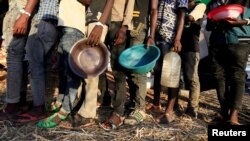 Des réfugiés éthiopiens qui ont fui la région de Tigré font la queue pour recevoir une aide alimentaire dans le camp d'Um-Rakoba dans l'État d'Al-Qadarif, à la frontière, au Soudan, le 11 décembre 2020.