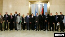 Special Representative of the Secretary-General for Libya and Head UNSMIL Bernardino Leon (C) poses with delegates for a group photograph after a news conference at the Palais des Nations in Geneva, Jan. 14, 2015.