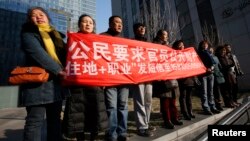 Sledbenici Šu Žijonga, istaknutog advokata za odbranu ljudskih prava uzvikuju slogane nedaleko od suda gde mu se sudi, Peking 22. januar 2014.