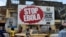 FILES - People walking past a billboard reading "Stop Ebola" in Freetown, Sierra Leone, Nov. 7, 2014. 