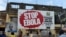 FILES - People walking past a billboard reading "Stop Ebola" in Freetown, Sierra Leone, Nov. 7, 2014. 