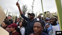 FILE—Christian worshippers march down a road, overlooking the Dome of the Rock mosque at the al-Aqsa mosque complex, during the traditional Palm Sunday procession at the Mount of Olives in Jerusalem on March 24, 2024.