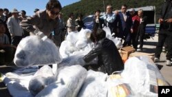 North Korean defectors carry plastic bags full of leaflets denouncing North Korea for canceling a planned reunion of Korean families, to be attached to balloons during a rally near the Unification Observation Post in Paju, South Korea, Oct. 4, 2013.