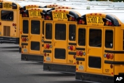 FILE - Fairfax County Public School buses are lined up at a maintenance facility in Lorton, Va., July 24, 2020.