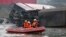 Rescue workers on a small boat search the wreckage of a test TGV train that derailed and crashed in a canal outside Eckwersheim near Strasbourg, eastern France, Nov. 14, 2015.