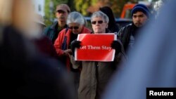 FILE - Demonstrators hold an "Interfaith Prayer Vigil for Immigrant Justice" outside the federal building, where ethnic Chinese Christians who fled Indonesia after wide-scale rioting decades ago and overstayed their visas in the U.S. must check-in with ICE, in Manchester, New Hampshire, Oct. 13, 2017. 