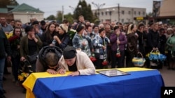 Mama Kateryna na familia yake wakilia juu ya jeneza la mtoto wake Ihor Kusochek, askari wa Kiukreni wa kikosi cha Azov ambaye aliuwawa kwenye mstari wa mbele huko Toretsk, katika mkoa wa Chernihiv, Ukraine, Ijumaa Oktoba 4, 2024. (AP).