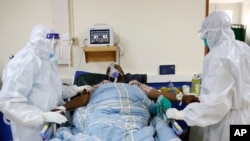 FILE - Medical staffers wearing protective gear attend to a COVID patient at a hospital in Machakos, Kenya, June 17, 2021.