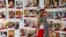 FILE - A woman walks past pictures of hostages in Tel Aviv, Israel, Februry 12, 2024. The Israeli military has rescued two hostages from captivity in the Gaza Strip.