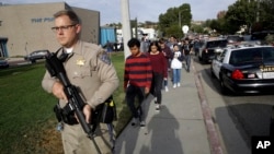 Polisi bersenjata mengamankan para siswa saat terjadi penembakan di Saugus High School di Santa Clarita, California, AS hari Kamis (14/11). 