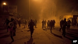 Des manifestants fuyant les tirs de gaz lacrymogène à Dakar le 27 janvier 2012