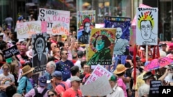 Marchers carry signs with historical LGBTQ figures during the Queer Liberation March in New York, Sunday, June 30, 2019. 