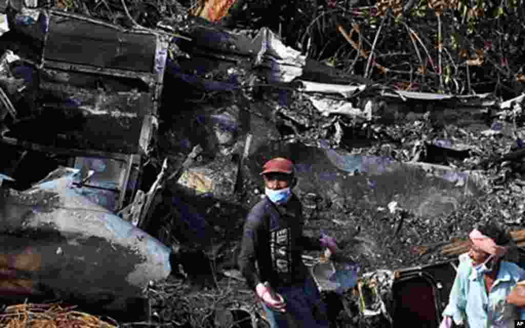 Indian laborers work at the plane crash site of the Air India Express Boeing 737-800 in Mangalore on 24 May 2010