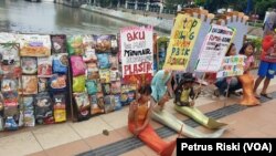 Sejumlah anak berpakaian ikan, berkampanye di jembatan Jalan Pemuda, Surabaya, dan mengajak masyarakat tidak membuang sampah ke sungai. (Foto: VOA/ Petrus Riski)