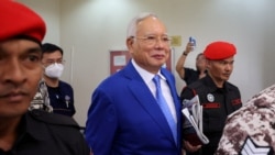 FILE - Former Malaysian Prime Minister Najib Razak escorted by prison officers as the jailed politician left the court after court proceedings in Kuala Lumpur, Malaysia January 19, 2024.