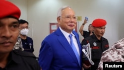 FILE - Former Malaysian Prime Minister Najib Razak escorted by prison officers as the jailed politician left the court after court proceedings in Kuala Lumpur, Malaysia January 19, 2024.