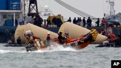 Rescatistas y buzos buscan cuerpos de gente atrapada en el ferry Sewol, en Corea del Sur, al que se le han instalado boyas para que no se hunda.