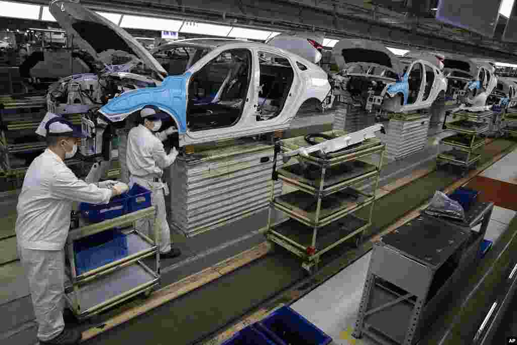 Los trabajadores ensamblan automóviles en la fábrica Dongfeng Honda Automobile Co., Ltd. Wuhan es un centro importante para la industria pesada, particularmente automóviles, y aunque muchas plantas importantes han reiniciado la producción, las pequeñas y medianas empresas que emplean a la mayoría de las personas siguen sufriendo tanto por la falta de trabajadores como por la demanda.