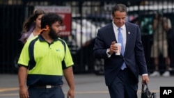 New York Gov. Andrew Cuomo, right, prepares to board a helicopter after announcing his resignation, Tuesday, Aug. 10, 2021, in New York. Cuomo says he will resign over a barrage of sexual harassment allegations.