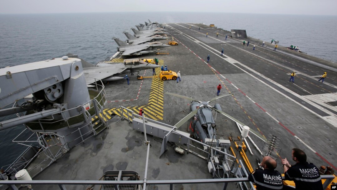 FILE - French sailors work on the flight deck of the French Navy aircraft carrier Charles de Gaulle in the Persian Gulf, March 17, 2015. 