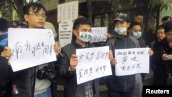 Manifestantes frente al semanario Southern Weekly en Cantón demandan constitucionalismo y libertad de expresión en China.