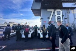 Menteri Pertahanan Lloyd Austin, kiri depan, berjalan di samping komandan USS Gerald R. Ford, Kapten Angkatan Laut Rick Burgess, depan, selama kunjungan mendadak ke kapal pada Rabu, 20 Desember 2023. (Foto: AP )