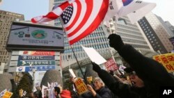 FILE - South Korean protesters wave U.S. and South Korean flags at a rally to support the deployment of THAAD, an advanced U.S. missile defense system, Feb, 15, 2017. 