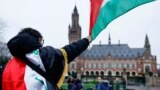 عالمی عدالت انصاف میں مقبوضہ فلسطینی علاقوں کے بارے میں سماعتوں کے موقع پر ایک فلسطینی اپنا پرچم لہرا رہا ہے۔ 21 فروری 2024