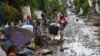 Residents clean their homes following flooding in Batangas City, south of Manila, Nov. 2, 2020, after Super Typhoon Goni made landfall in the Philippines.
