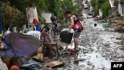 Residents clean their homes following flooding in Batangas City, south of Manila, Nov. 2, 2020, after Super Typhoon Goni made landfall in the Philippines.