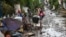 Residents clean their homes following flooding in Batangas City, south of Manila, Nov. 2, 2020, after Super Typhoon Goni made landfall in the Philippines.